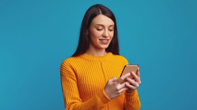 Vrouw lachend achter telefoon, spel speelt