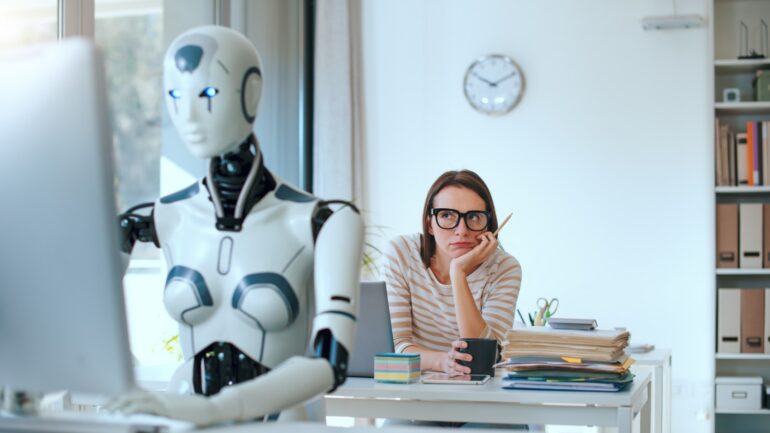 Kantoor met robot en vrouw die verveeld kijkt ter illustratie van AI-implementatie die cultuur onder druk zet