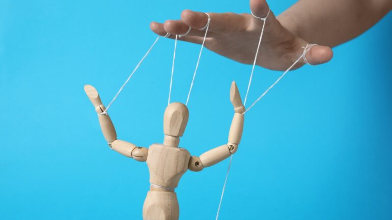 Houten marionet die bestuurd wordt ter illustratie van effectieve call-to-action met hulp van bei?nvloedingspsychologie