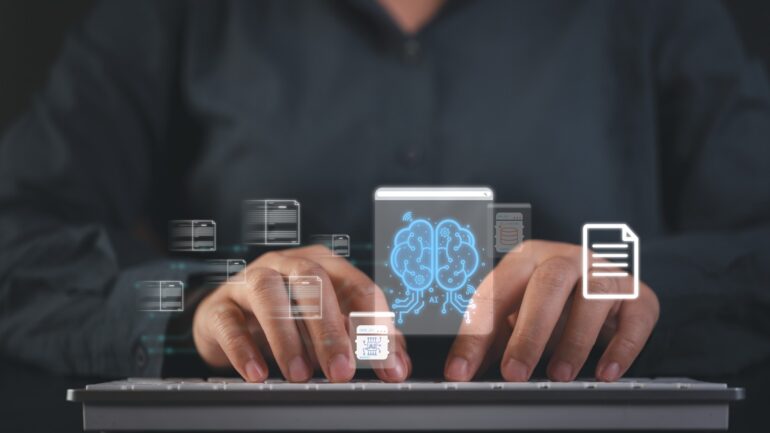 Typende handen op een computer met AI erop afgebeeld.