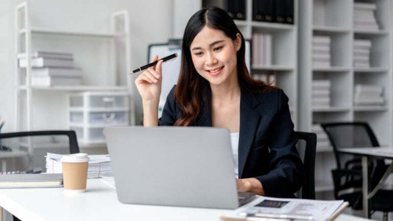 Een vrouw glimlachend achter haar laptop