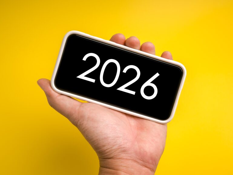 Een hand met een telefoon waar 2026 op staat.