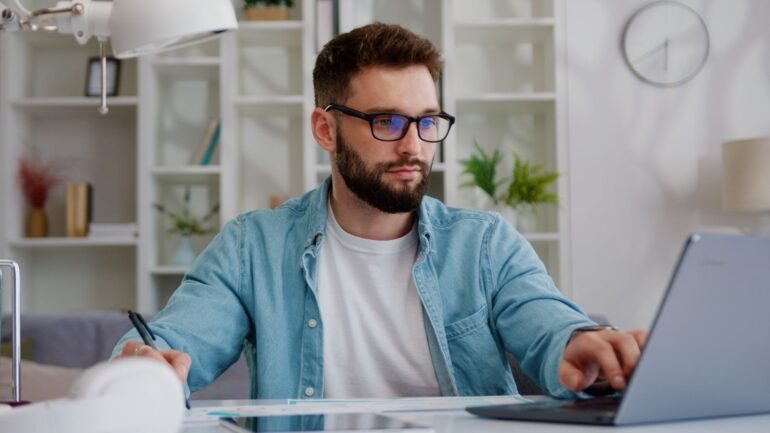 Man werkend achter laptop