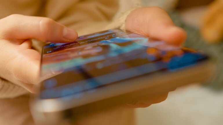 Een vrouw scrollt op social media op haar telefoon.