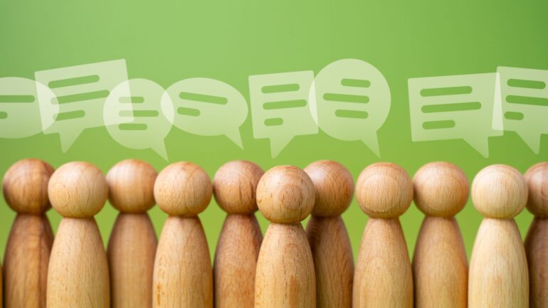 Houten poppetjes met spreekwolkjes.