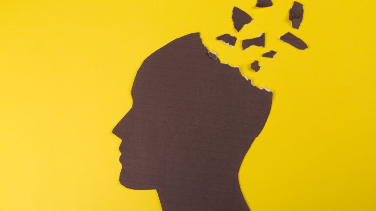 Papieren silhouet van hoofd met snippers bij achterhoofd ter illustratie van verliezen denkkracht door AI