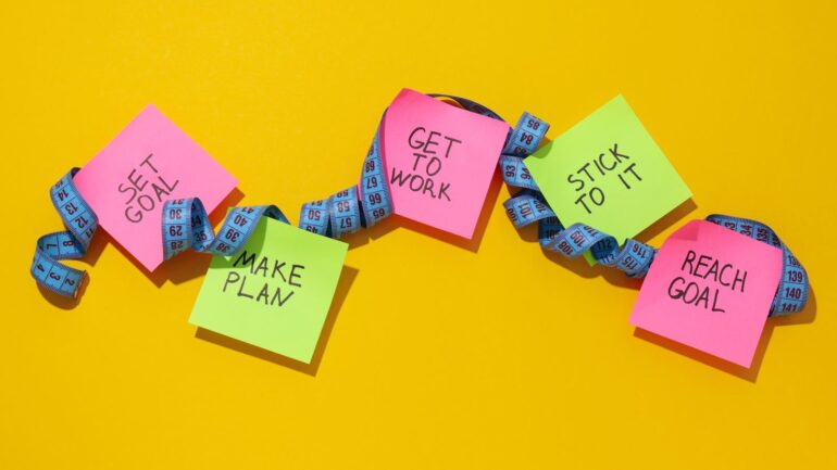 Meetlint met post-its met motiverende teksten om routines te creeren bij artikel over AI-routine