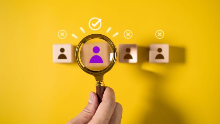 Vergrootglas met houten blokken met poppetjes.