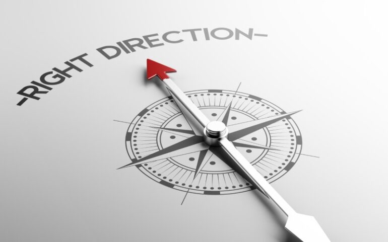 Decoratief beeld van kompas die de tekst 'right direction' aanwijst