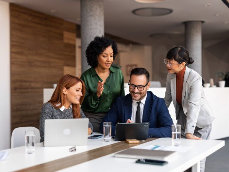 Groep collega's die samenwerken rond een tafel