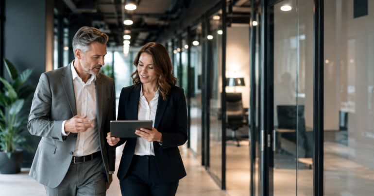 Twee zakelijke professionals bespreken AI-workflows en automatisering op een tablet in een moderne kantooromgeving