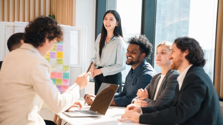 Lachende collega's aan een vergadertafel tijdens een meeting